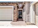 Close-up of front entrance highlighting stone accents, a gated doorway, and a two-car garage on the left at 10664 E Ellis St, Mesa, AZ 85207