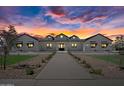Beautiful white modern farmhouse exterior with black roof at sunset at 11564 E Windsor Way, Florence, AZ 85132