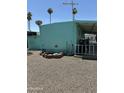 Turquoise mobile home with a gravel yard, patio, and mature trees at 150 S Windsor Dr # 35, Mesa, AZ 85204