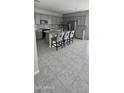 Modern kitchen with gray cabinetry, granite countertops, stainless steel appliances, and a central island with seating at 17423 W Country Club Ter, Surprise, AZ 85387