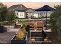 Inviting backyard patio with a fire pit and comfortable seating, complemented by lush landscaping and modern home at 17629 W Middlebury St, Surprise, AZ 85388