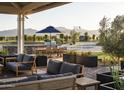 Inviting outdoor patio with comfortable seating and a dining area under a shaded pergola, overlooking the community at 17629 W Middlebury St, Surprise, AZ 85388