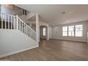 Bright and airy living room with hardwood floors, neutral paint, and an open staircase leading to the second floor at 18123 W Lundberg St, Surprise, AZ 85388