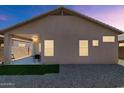 Exterior view of the house with a covered patio, gravel yard, and small patch of grass at 19860 N 110Th Ln, Peoria, AZ 85373
