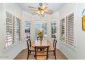 Bright breakfast nook features a wood table and chairs by shuttered windows at 19860 N 110Th Ln, Peoria, AZ 85373