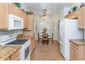 Eat-in kitchen with tile floors, tan cabinets, granite countertops, and stainless steel appliances at 19860 N 110Th Ln, Peoria, AZ 85373