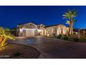 Inviting single-story home with brick-paved driveway, well-maintained landscaping, and a three-car garage at 20151 E Via Del Palo St, Queen Creek, AZ 85142