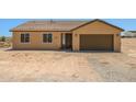Tan single-Gathering home showcasing a brown garage door and matching door with two windows and a simple landscape at 21859 W Gail Dr, Buckeye, AZ 85326