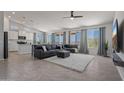 Open-concept living room featuring a large gray sofa, white rug, tiled floors, and scenic outdoor views through big windows at 21859 W Gail Dr, Buckeye, AZ 85326