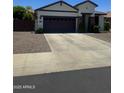 Charming single-story home with a well-manicured front yard, dark two-car garage, and neutral tones at 2715 E Canyon Creek Dr, Gilbert, AZ 85295