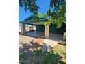 View of a property with a covered parking area and greenery, shaded by a tree at 5016 W Sunrise Dr, Laveen, AZ 85339