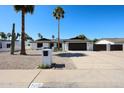 Charming single-story home features desert landscaping, dark trim, a two-car garage, and solar panels at 5259 E Karen Dr, Scottsdale, AZ 85254