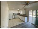 Efficient kitchen features white cabinets, tile flooring, and sliding door access to outdoor space at 6565 N 19Th Ave # 38, Phoenix, AZ 85015