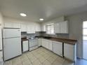 Well-lit kitchen with white appliances, tile flooring, and efficient layout at 6565 N 19Th Ave # 38, Phoenix, AZ 85015
