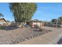 Inviting single-story home with desert landscaping including river rock, cacti, and flowering plants at 7132 W Vermont Ave, Glendale, AZ 85303