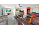 Comfortable living room with leather sofas, ceiling fan, tile floor, and dining area, offering a relaxing and inviting space at 7132 W Vermont Ave, Glendale, AZ 85303