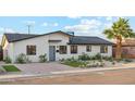 Charming single-story home featuring manicured landscaping, desert plants, and a brick driveway, offering great curb appeal at 7432 E Holly St, Scottsdale, AZ 85257