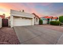 View of a house with red tile roof, attached two-car garage, and desert landscaping at 11358 E Jenan Dr, Scottsdale, AZ 85259