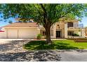 Attractive two-story house featuring white stucco, a Spanish tile roof, and a large front yard tree at 119 E Palomino Dr, Tempe, AZ 85284