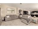 Spacious living room with modern gray sofas, neutral decor, and tile flooring at 1343 E Amberwood Dr, Phoenix, AZ 85048