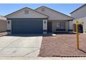 Charming single-story home featuring a blue garage door and low-maintenance desert landscaping at 13606 N 130Th Ave, El Mirage, AZ 85335