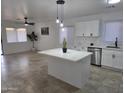 Bright, modern kitchen with an island, sleek appliances, and adjacent living area for open-concept living at 13606 N 130Th Ave, El Mirage, AZ 85335