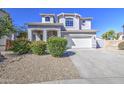 Beautiful two-story home with a three-car garage, arched entryway, and green, flowering shrubs at 14719 N 176Th Ave, Surprise, AZ 85388
