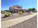 Charming two-story home with well-maintained desert landscaping and a sidewalk that leads directly to the house at 15656 W Desert Mirage Dr, Surprise, AZ 85379