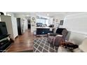 Open living room flowing into the kitchen, featuring hardwood floors and a comfortable recliner at 17200 W Bell Rd # 1622, Surprise, AZ 85374
