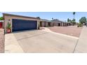 Wide concrete driveway leading to an attached garage, with desert landscaping at 1809 S Heritage --, Mesa, AZ 85210