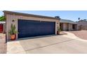 Attached garage with a dark blue door and concrete driveway, with desert landscaping at 1809 S Heritage --, Mesa, AZ 85210