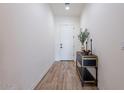 Bright entryway with wood-look tile flooring, a decorative table, and fresh white walls at 1956 W Kinfield Trl, Phoenix, AZ 85085