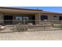 Spacious backyard with desert landscaping, wrought iron fence, and covered outdoor patio area at 20332 N Denizen Dr, Surprise, AZ 85387