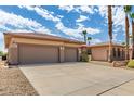 Spacious three-car garage and front exterior of a well maintained desert home at 20332 N Denizen Dr, Surprise, AZ 85387