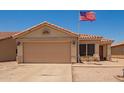 Attractive single-story home with a two-car garage, desert landscaping, and an American flag at 2202 S Lawther Dr, Apache Junction, AZ 85120