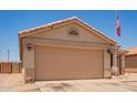 A tan home featuring a two-car garage and desert landscaping in the front at 2202 S Lawther Dr, Apache Junction, AZ 85120