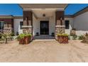 Inviting home entrance, featuring stone pillars and decorative planters, adding charm and curb appeal at 22414 W Meade Ln, Buckeye, AZ 85326