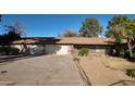 Single-story home featuring a two-car garage, desert landscaping, and a concrete driveway at 3323 N 103Rd Ave, Avondale, AZ 85392