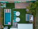 Aerial view of a backyard oasis with a sparkling pool, lounge area, lush landscaping, and shaded seating at 4036 N 40Th Pl, Phoenix, AZ 85018