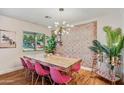 Elegant dining room featuring hardwood floors, a rustic table, exposed brick wall, and stylish light fixture at 4036 N 40Th Pl, Phoenix, AZ 85018