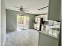 Open-concept kitchen with white cabinets, stainless steel appliances, and a view to the backyard at 4104 N 113Th Ave, Phoenix, AZ 85037