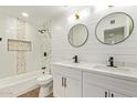 Stylish bathroom featuring double vanity with modern fixtures and a tiled shower with tub at 4701 N 63Rd Dr, Phoenix, AZ 85033