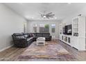 Inviting living room with a plush leather sofa, ceiling fan, neutral paint, and wood-look floors at 10165 E Gamma Ave, Mesa, AZ 85212