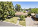 Inviting single-story home with a brick pathway, lush lawn, mature trees, and a brick driveway at 1274 E Edgemont Ave, Phoenix, AZ 85006