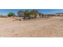 Exterior shot of the home with a desert yard and chain link fence at 1347 S Oak Rd, Maricopa, AZ 85139