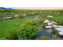 Aerial view of a desert home near a golf course, surrounded by lush greenery and a winding driveway at 1637 N Quartz Valley Rd, Scottsdale, AZ 85266