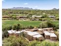 Aerial view of a home featuring a golf course view, a tile roof, desert landscaping, and surrounding mountains at 1637 N Quartz Valley Rd, Scottsdale, AZ 85266