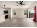 An open living space with ceramic tile floors, a ceiling fan, and a view of the kitchen and backyard at 1748 W Cameron Blvd, Coolidge, AZ 85128