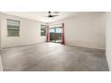 A spacious living room featuring ceramic tile floors, a modern ceiling fan, and a sliding door to the outside at 1748 W Cameron Blvd, Coolidge, AZ 85128