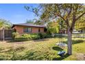 Landscaped front yard with mature tree and a charming tire swing at 1825 E Palo Verde Dr, Phoenix, AZ 85016